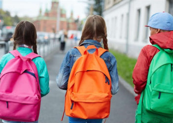 Escolares caminando con mochilas - iStock