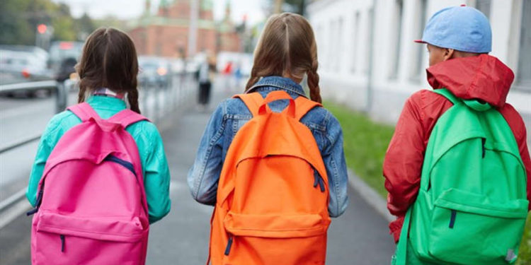 Escolares caminando con mochilas - iStock