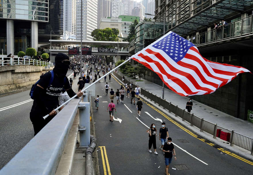 Los manifestantes ondean banderas estadounidenses y gritan consignas mientras marchan desde Chater Garden al Consulado de los Estados Unidos en Hong Kong, el 8 de septiembre de 2019 (AP Photo / Vincent Yu)