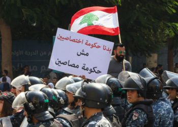 Un manifestante libanés sostiene la bandera nacional y una pancarta que dice en árabe "Queremos un gobierno de especialistas, no un gobierno de tontos" durante una manifestación en el centro de la Plaza Mártir de Beirut el 29 de septiembre de 2019. (ANWAR AMRO / AFP)