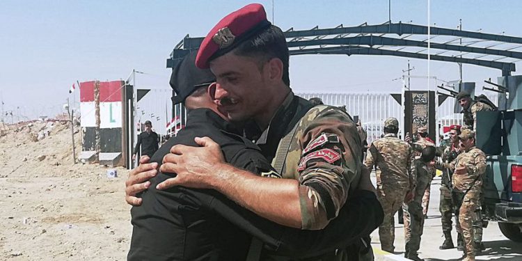 Los soldados de la guardia fronteriza iraquí y siria se felicitan durante la ceremonia de inauguración del cruce entre la ciudad iraquí de Qaim y Boukamal de Siria en la provincia de Anbar, Iraq, 30 de septiembre de 2019. (Foto AP / Hadi Mizban)