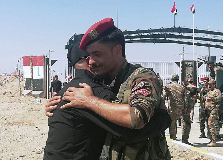 Los soldados de la guardia fronteriza iraquí y siria se felicitan durante la ceremonia de inauguración del cruce entre la ciudad iraquí de Qaim y Boukamal de Siria en la provincia de Anbar, Iraq, 30 de septiembre de 2019. (Foto AP / Hadi Mizban)