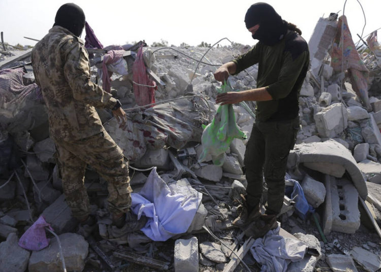 La gente mira una casa destruida cerca de la aldea de Barisha, en la provincia de Idlib, Siria, el 27 de octubre, luego de una operación del ejército estadounidense que atacó a Abu Bakr al-Baghdadi, el líder en la sombra del grupo Estado Islámico | Foto: AP / Ghaith Alsayed