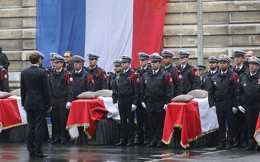 El presidente francés, Emmanuel Macron, se para frente a los ataúdes durante una ceremonia en la Prefectura de Policía de París (Sede de la Policía de París) en París el 8 de octubre de 2019, para rendir homenaje a las víctimas de un ataque en la prefectura el 4 de octubre de 2019. (LUDOVIC MARIN / AFP)