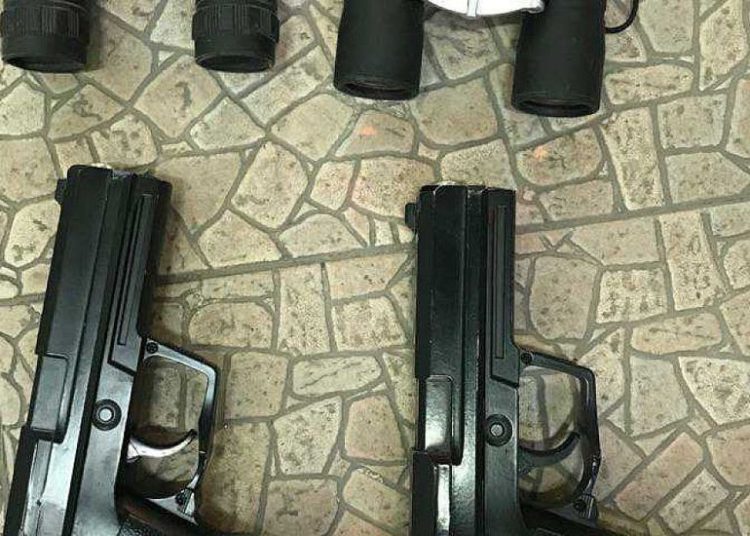 Esta foto sin fecha publicada por la policía el 6 de octubre de 2019 muestra armas y binoculares encontrados durante una redada en la casa de un hombre del pueblo beduino sureño de Tel Sheva sospechoso de querer luchar por el grupo yihadista del Estado Islámico en Siria. (Policía de Israel)
