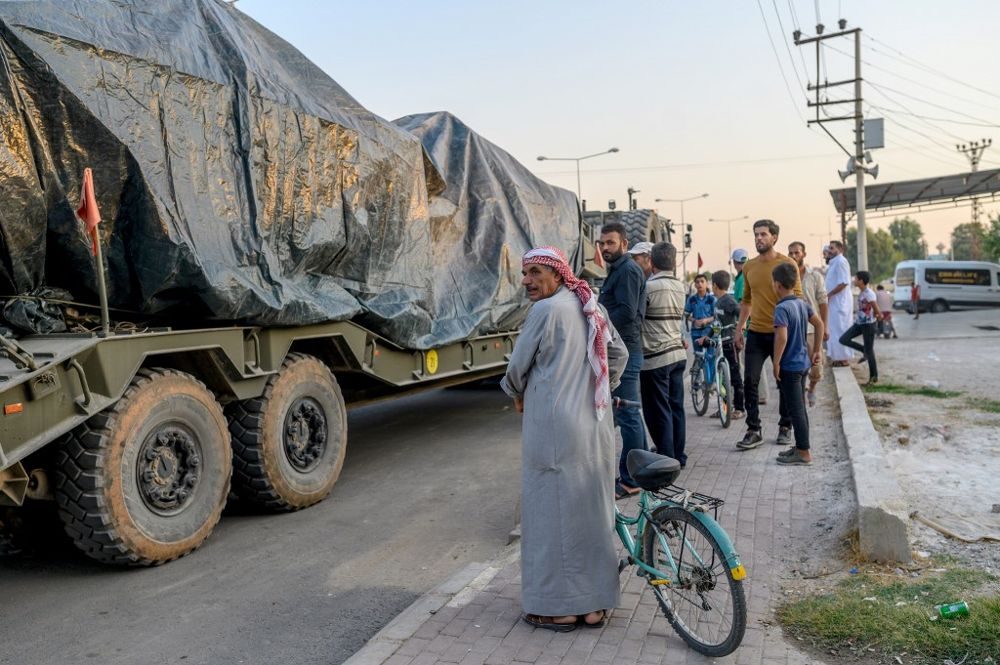 Los civiles turcos miran el convoy de un ejército turco que se dirige hacia la frontera siria cerca de Akcakale en la provincia de Sanliurfa el 9 de octubre de 2019 (BULENT KILIC / AFP)