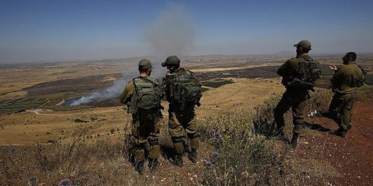 Ilustrativo: los soldados israelíes en una base del ejército en los Altos del Golán miran a través de la frontera con Siria el 7 de julio de 2018. (Foto de AFP / Jalaa Marey)