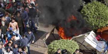 Los partidarios de Hezbolá, a la izquierda, queman tiendas de campaña en el campamento de protesta establecido por manifestantes antigubernamentales cerca del palacio de gobierno, en Beirut, Líbano, el 29 de octubre de 2019 (Foto AP / Hussein Malla)