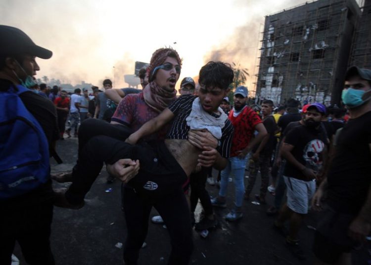 Un manifestante iraquí lleva a un compañero herido durante una manifestación contra la corrupción estatal, el fracaso de los servicios públicos y el desempleo en la plaza Tayaran en Bagdad el 2 de octubre de 2019. (AHMAD AL-RUBAYE / AFP)