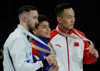 (LR) Artem Dolgopyat de Israel, segundo clasificado, Carlos Edriel Yulo, ganador de Filipinas, y Xiao Ruoteng, de China, posan en el podio durante la ceremonia de entrega de medallas para el evento de piso masculino en el Campeonato Mundial de Gimnasia Artística FIG en el Hanns-Martin-Schleyer-Halle en Stuttgart, sur de Alemania, el 12 de octubre de 2019. (Lionel BONAVENTURE / AFP)