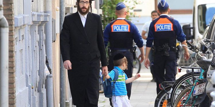 Ilustrativo: un judío ortodoxo y un niño pasan a dos policías en Amberes, Bélgica, el 25 de mayo de 2014. (Foto AP / Yves Logghe)