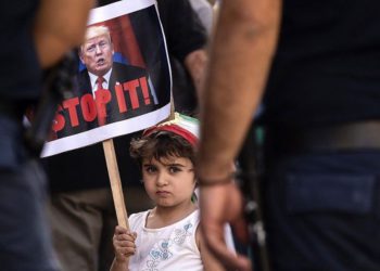 Una niña lleva una pancarta del presidente de Estados Unidos, Donald Trump, mientras marchan en la capital chipriota de Nicosia el 12 de octubre de 2019, para protestar contra la ofensiva turca en las ciudades controladas por los kurdos en el norte de Siria. (Iakovos Hatzistavrou / AFP)
