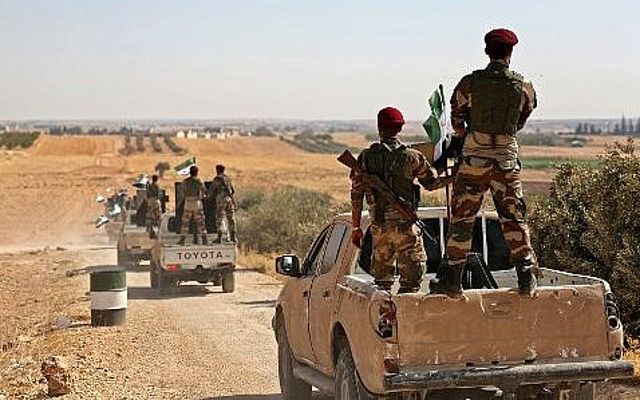 Los combatientes rebeldes sirios respaldados por Turquía se dirigen a un área cerca de la frontera sirio-turca al norte de Alepo el 8 de octubre de 2019 (Nazeer Al-khatib / AFP)