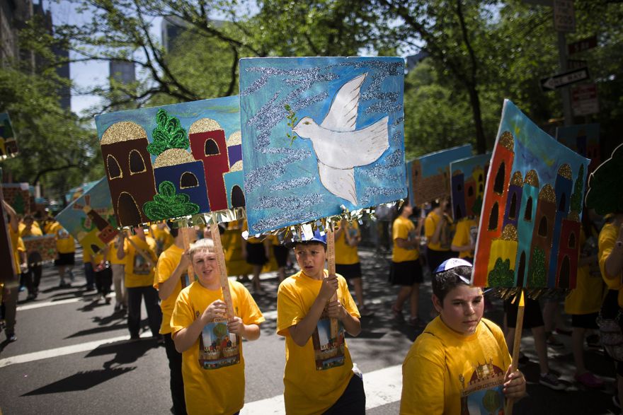 En esta foto de archivo del domingo 1 de junio de 2014, un niño lleva un cartel de paloma de la paz con otros de una escuela judía durante el desfile Celebrate Israel en Nueva York. (Foto AP / John Minchillo)
