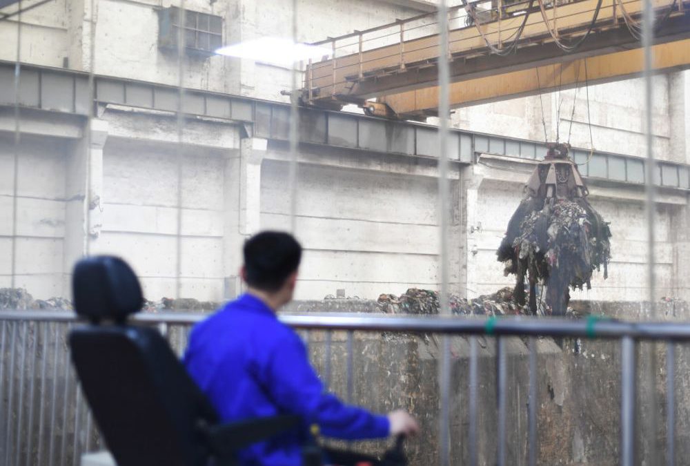 Un trabajador opera una grúa levantando basura para su incineración en una planta de conversión de residuos en energía en Kaili, Qiandongnan Miao y la Prefectura Autónoma de Dong, provincia de Guizhou, China, 2 de junio de 2019. Fotografía tomada el 2 de junio de 2019 a través de una ventana de vidrio. (Crédito de la foto: REUTERS / STRINGER)