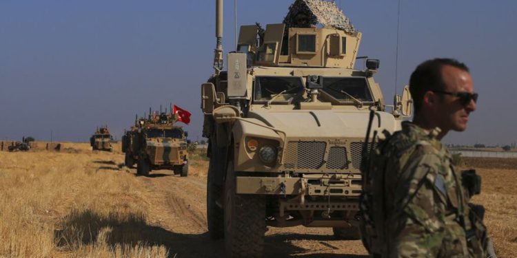 Patrullas de vehículos blindados turcos y estadounidenses mientras realizan patrullas conjuntas en tierra en la llamada "zona segura" en el lado sirio de la frontera con Turquía, cerca de la ciudad de Tal Abyad, en el noreste de Siria, el 4 de octubre | Foto: AP Photo / Baderkhan Ahmad