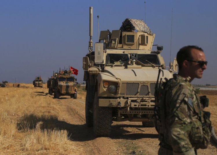 Patrullas de vehículos blindados turcos y estadounidenses mientras realizan patrullas conjuntas en tierra en la llamada "zona segura" en el lado sirio de la frontera con Turquía, cerca de la ciudad de Tal Abyad, en el noreste de Siria, el 4 de octubre | Foto: AP Photo / Baderkhan Ahmad