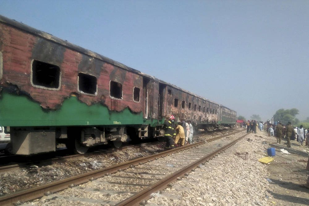 Funcionarios pakistaníes examinan un tren dañado por un incendio en Liaquatpur, Pakistán, 31 de octubre de 2019. (Siddique Baluch / AP)