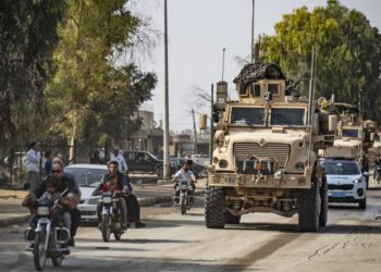 Los vehículos militares estadounidenses conducen en una calle en la ciudad de Tal Tamr el 20 de octubre de 2019, después de salir de su base. (Foto por Delil SOULEIMAN / AFP)