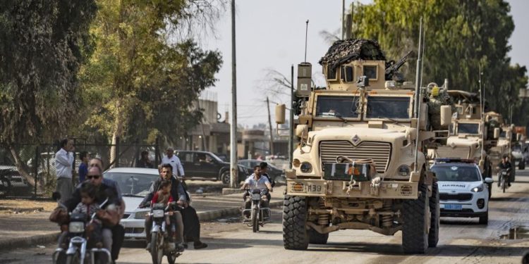 Los vehículos militares estadounidenses conducen en una calle en la ciudad de Tal Tamr el 20 de octubre de 2019, después de salir de su base. (Foto por Delil SOULEIMAN / AFP)