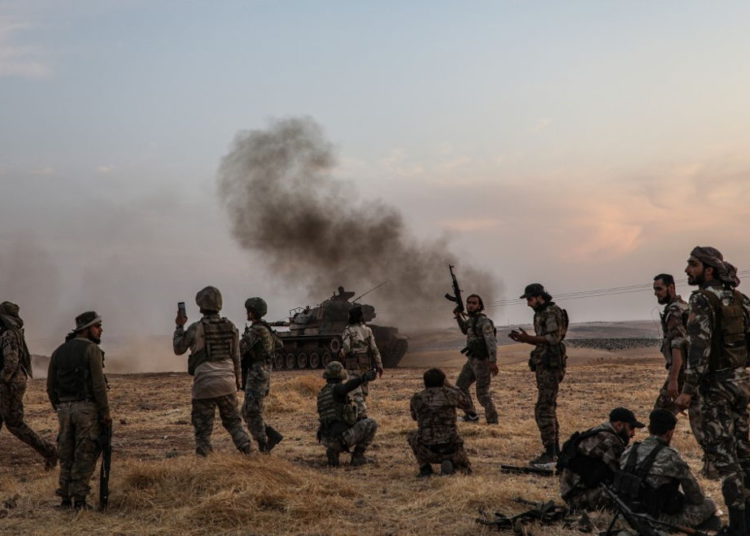 Soldados turcos y combatientes sirios respaldados por Turquía se reúnen en las afueras del norte de la ciudad siria de Manbij, cerca de la frontera turca, el 14 de octubre de 2019, mientras Turquía y sus aliados continúan atacando las ciudades fronterizas controladas por los kurdos en el noreste de Siria. (Zein Al Rifai / AFP)