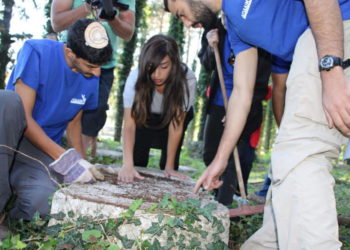 Estudiantes israelíes de la Asociación Ayalim arreglan lápidas olvidadas en el cementerio judío de Ioannina en Grecia. (crédito de la foto: AYALIM)