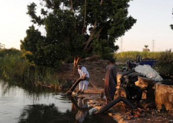 Los agricultores usan una máquina en un canal que desemboca en el río Nilo, al sur de Luxor