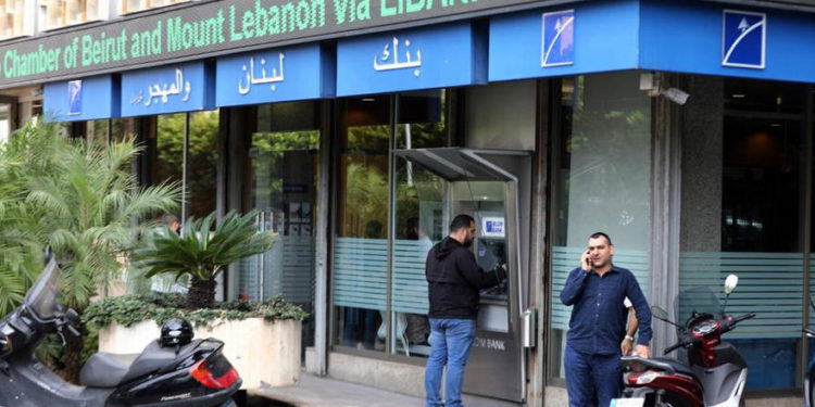 Un hombre retira dinero del cajero automático a la entrada de un banco en Beirut el 1 de noviembre de 2019 (JOSEPH EID / AFP)
