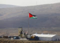 Una foto tomada desde el lado israelí de la frontera muestra a soldados jordanos izando la bandera nacional antes de una ceremonia en el sitio del Valle del Jordán de Naharayim, también conocido como Baqura en Jordania, al este del río Jordán el 10 de noviembre de 2019 (MENAHEM KAHANA / AFP)