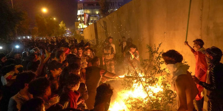 Los manifestantes iraquíes incendiaron neumáticos cerca del muro que rodea el consulado iraní en la ciudad de Karbala, al sur de la capital iraquí, Bagdad, durante la noche del 3 de noviembre de 2019. (Mohammed SAWAF / AFP)