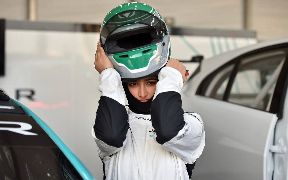 Reema al-Juffali, la primera mujer piloto de Arabia Saudita, se ajusta el casco frente a su automóvil durante una entrevista con AFP en el distrito de Diriyah en Riad el 20 de noviembre de 2019. (Fayez Nureldine / AFP)