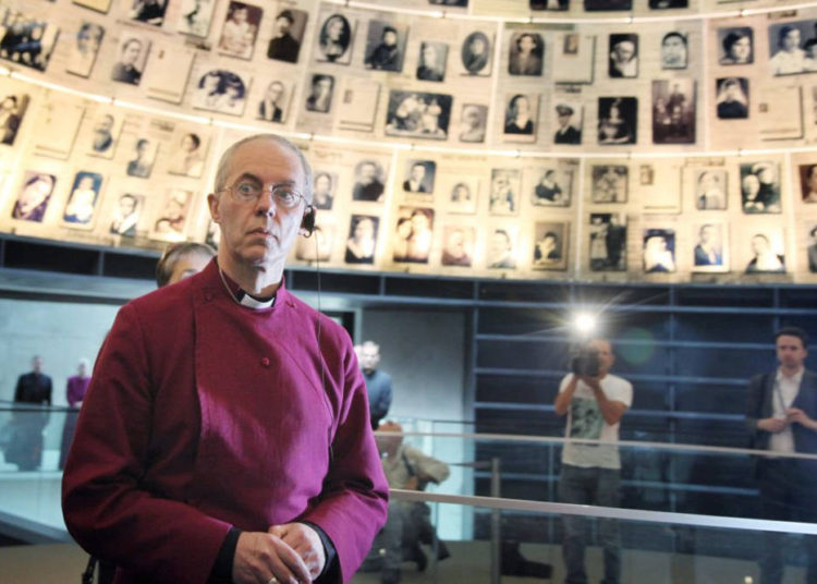 El actual arzobispo de Canterbury y obispo principal de la Iglesia de Inglaterra, Justin Welby, mira hacia arriba y a su alrededor fotografías de víctimas individuales del Holocausto en el Salón de los Nombres en el museo Memorial del Holocausto Yad Vashem en Jerusalén. 27 de junio de 2013. (Isaac Harari / FLASH90)