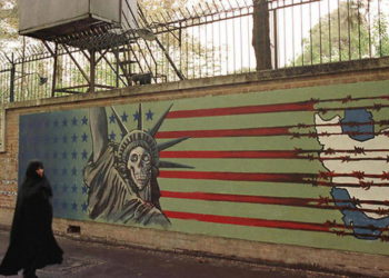 Una mujer iraní pasa junto a un mural antiestadounidense en la antigua embajada estadounidense en Teherán, el 3 de noviembre de 1999.