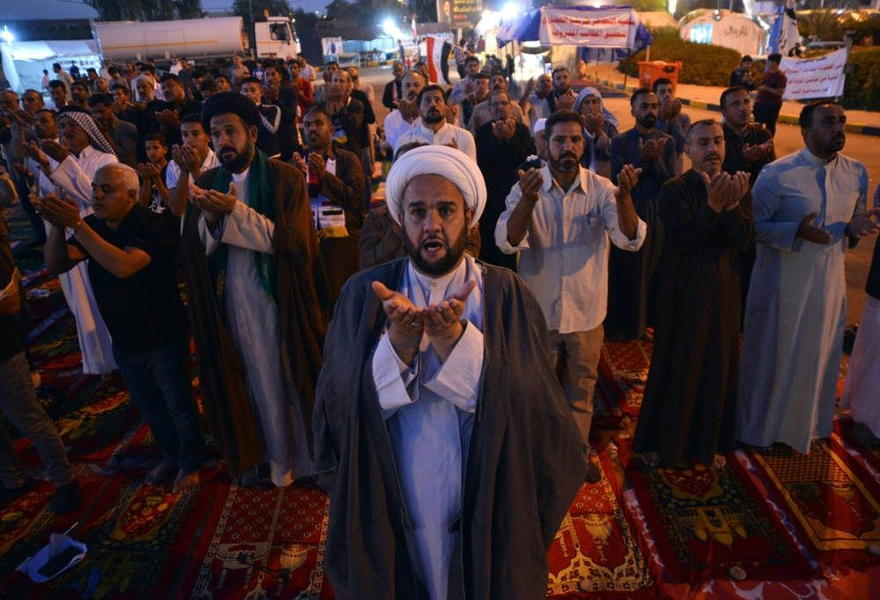 Los manifestantes iraquíes participan en oraciones colectivas durante las manifestaciones antigubernamentales en curso en la ciudad central del santuario sagrado de Najaf, el 10 de noviembre de 2019. (Haidar Hamdani / AFP)