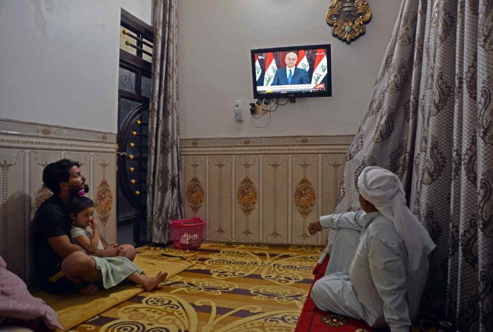 Los iraquíes miran un discurso televisado del presidente de Iraq, Barham Saleh, en la ciudad central del santuario de Najaf el 31 de octubre de 2019. (Foto de Haidar HAMDANI / AFP)