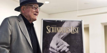 El sobreviviente croata de Auschwitz, Branko Lustig, se encuentra junto a un póster de la película La lista de Schindler en el memorial del Holocausto Yad Vashem en Jerusalén, 22 de julio de 2015. (Nir Elias / Pool Photo vía AP)