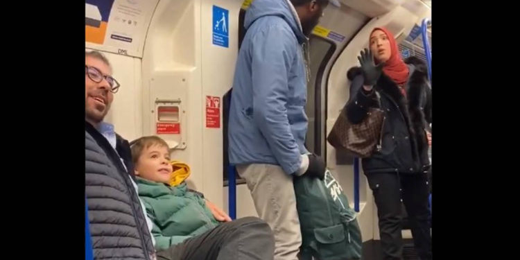 Se ve a una mujer musulmana (R) tratando de evitar que un hombre (C) grite abuso antisemita a una familia judía con niños pequeños en el metro de Londres el 22 de noviembre de 2109 (Captura de pantalla / Twitter)