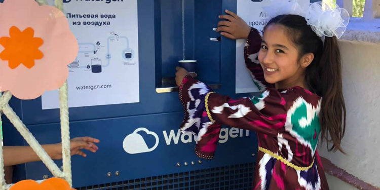 Una niña en Bukhara, Uzbekistán, toma muestras de agua de un generador de agua atmosférica conocido como "GEN-350", mayo de 2019. Crédito: Watergen.