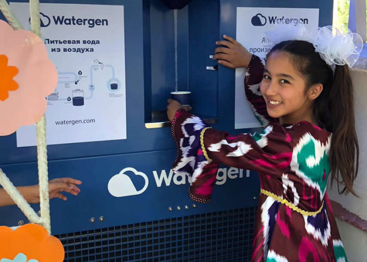 Una niña en Bukhara, Uzbekistán, toma muestras de agua de un generador de agua atmosférica conocido como "GEN-350", mayo de 2019. Crédito: Watergen.