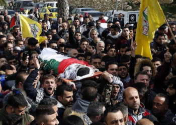 Los familiares lloran sobre el cuerpo de Hamzeh Yousef Zamaareh, durante su funeral en la ciudad cisjordana de Halhul, el 17 de febrero de 2018. (AFP Photo / Hazem Bader)
