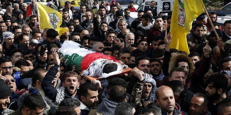 Los familiares lloran sobre el cuerpo de Hamzeh Yousef Zamaareh, durante su funeral en la ciudad cisjordana de Halhul, el 17 de febrero de 2018. (AFP Photo / Hazem Bader)