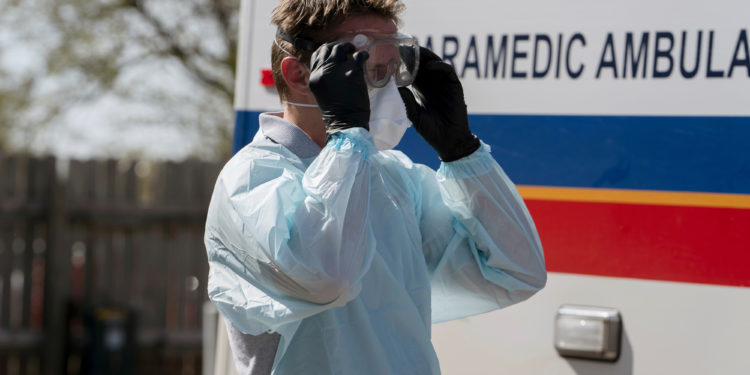 REACT EMS paramedic Brian Myers dons protective gear to transport a potential coronavirus disease (COVID-19) patient in Shawnee, Oklahoma, U.S. March 26, 2020. REUTERS/Nick Oxford
