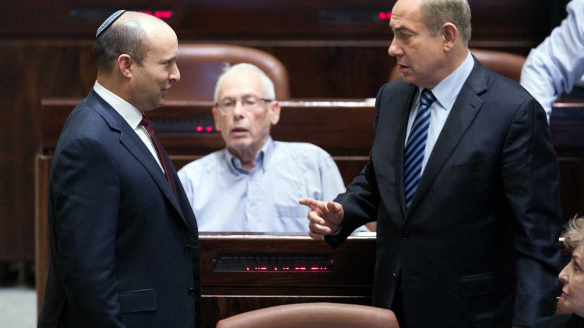 El primer ministro Benjamin Netanyahu, a la derecha, habla con el entonces ministro de Educación Naftali Bennett durante una sesión plenaria en la Knesset, el 5 de diciembre de 2016. (Yonatan Sindel/Flash90)