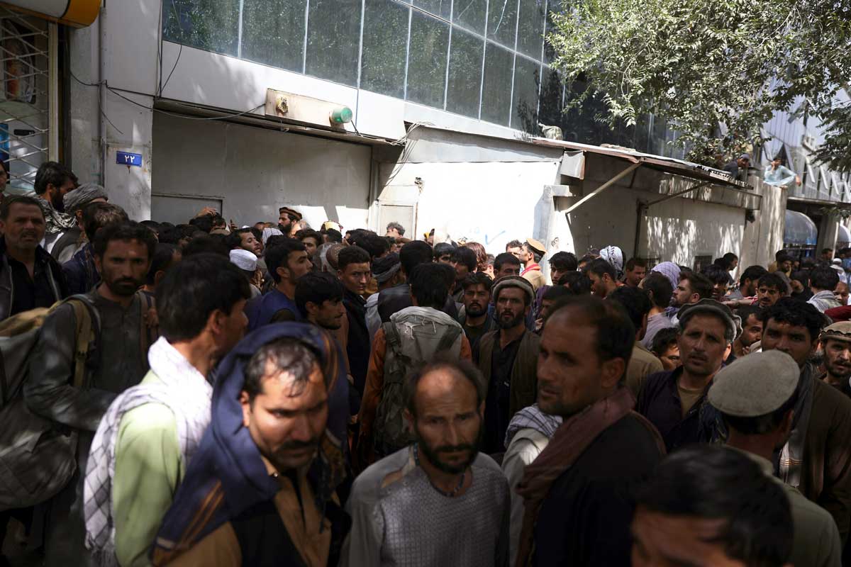 Los afganos esperan en largas colas durante horas para tratar de retirar dinero frente al Banco de Kabul, en Kabul, Afganistán, el domingo 15 de agosto de 2021. (AP Photo/Rahmat Gul) (AP Photo/Rahmat Gul)