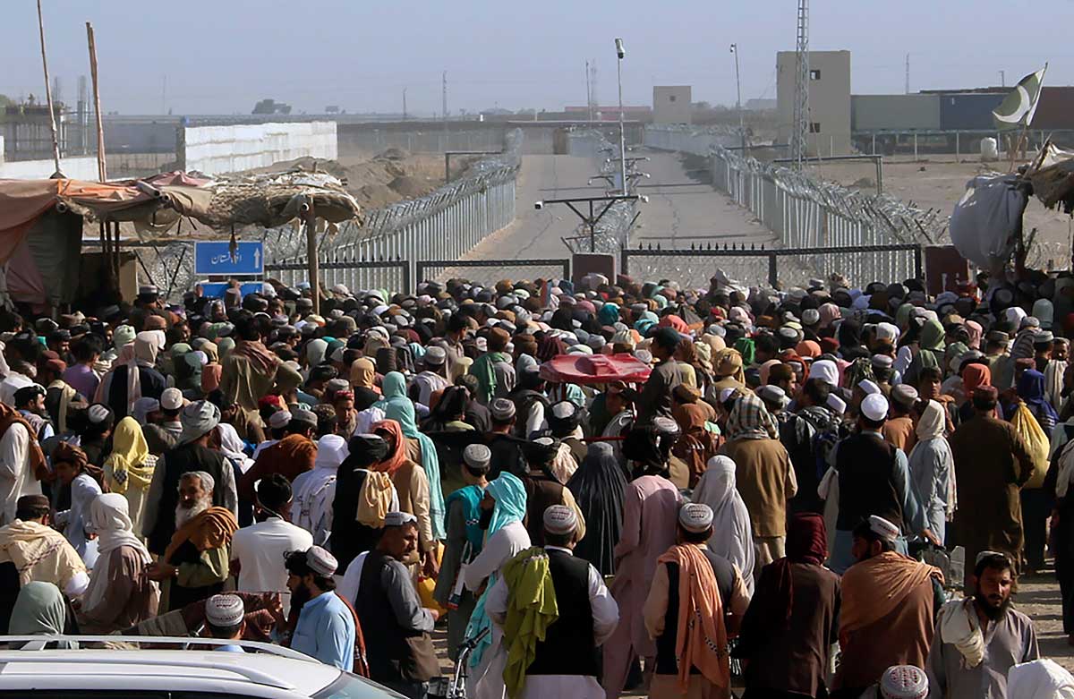 Personas varadas se reúnen para pedir información a las fuerzas de seguridad sobre la apertura del paso fronterizo entre Pakistán y Afganistán que fue cerrado por las autoridades hace unos días, en Chaman, Pakistán, el 11 de agosto de 2021. (AP/Jafar Khan)