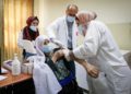 Trabajadores médicos palestinos reciben una vacuna contra el coronavirus en un centro médico de la ciudad cisjordana de Dura el 21 de marzo de 2021. (Wisam Hashlamoun/FLASH90)