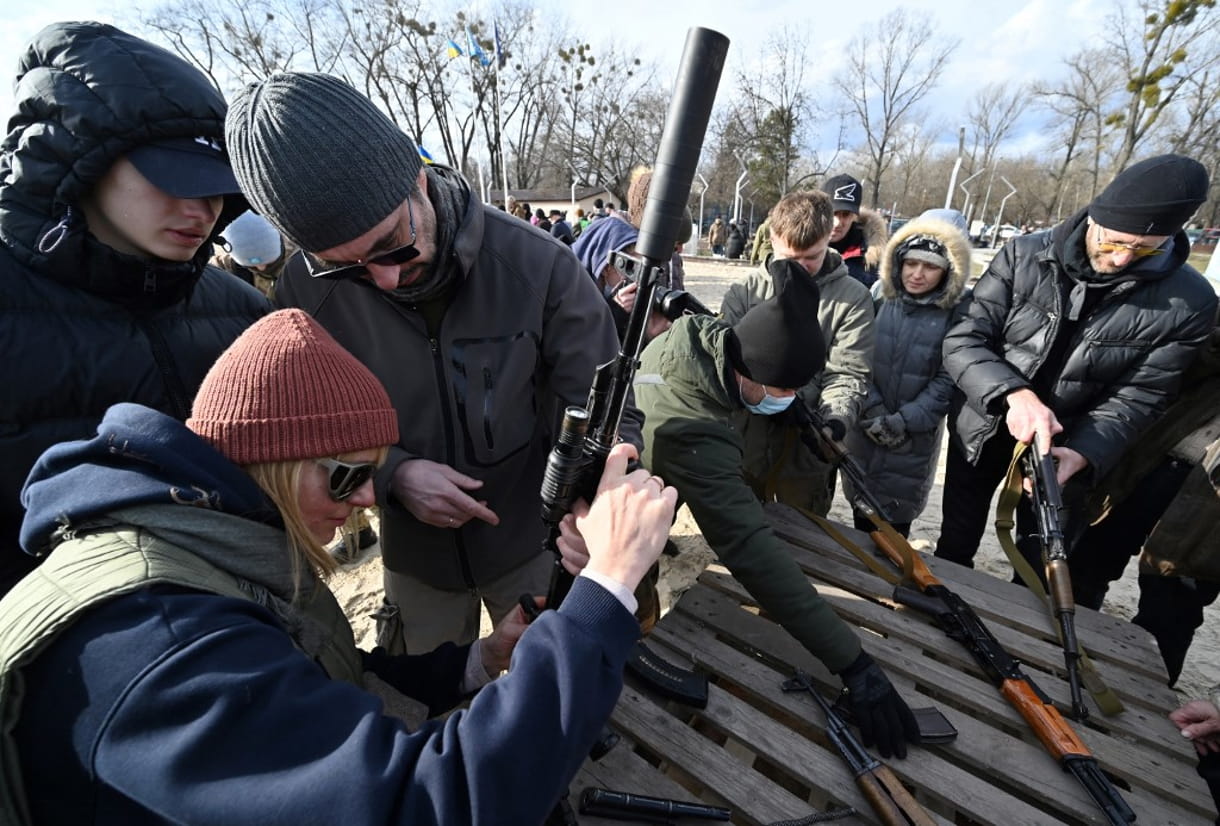 Residentes asisten a un entrenamiento abierto organizado para civiles por veteranos de guerra y voluntarios que enseñan el manejo básico de armas y primeros auxilios en una de las playas de la ciudad de Kiyv el 20 de febrero de 2022 (Genya SAVILOV / AFP)