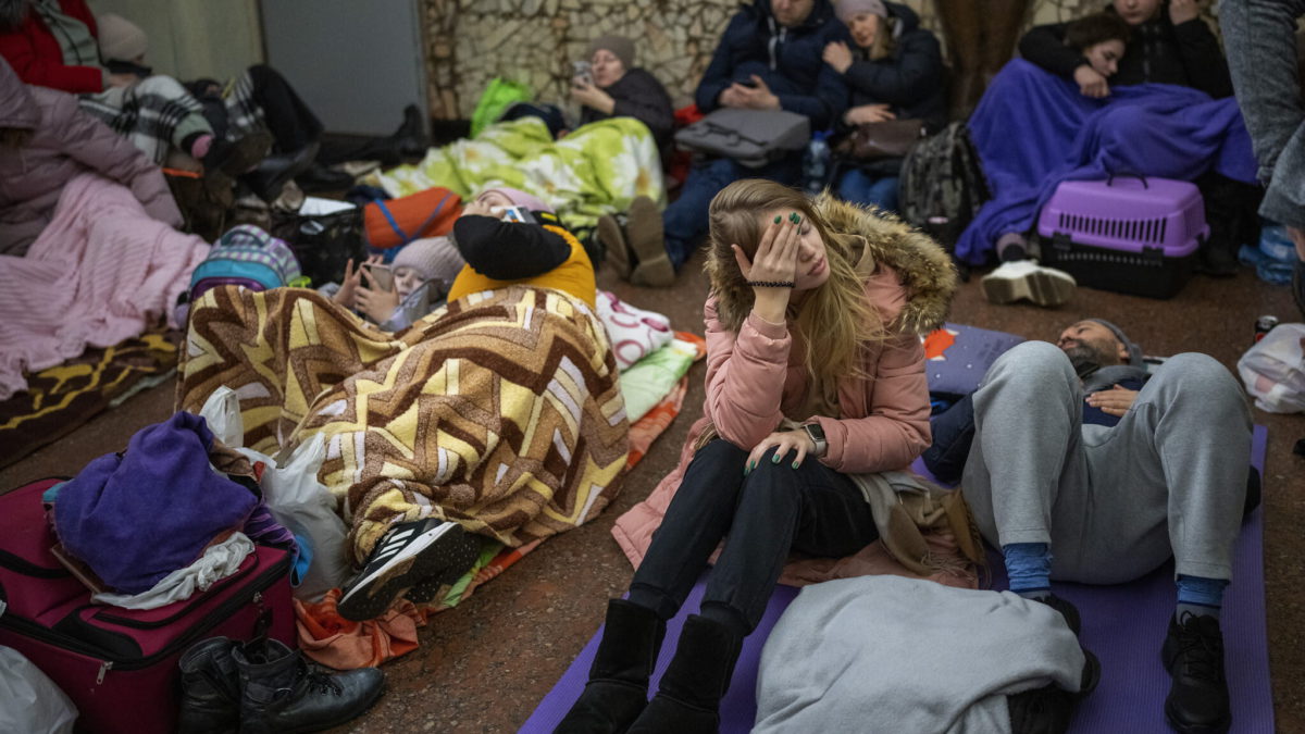 La gente descansa en el metro de Kiev, utilizándolo como refugio antibombas en Kiev, Ucrania, el jueves 24 de febrero de 2022. (AP Photo/Emilio Morenatti)