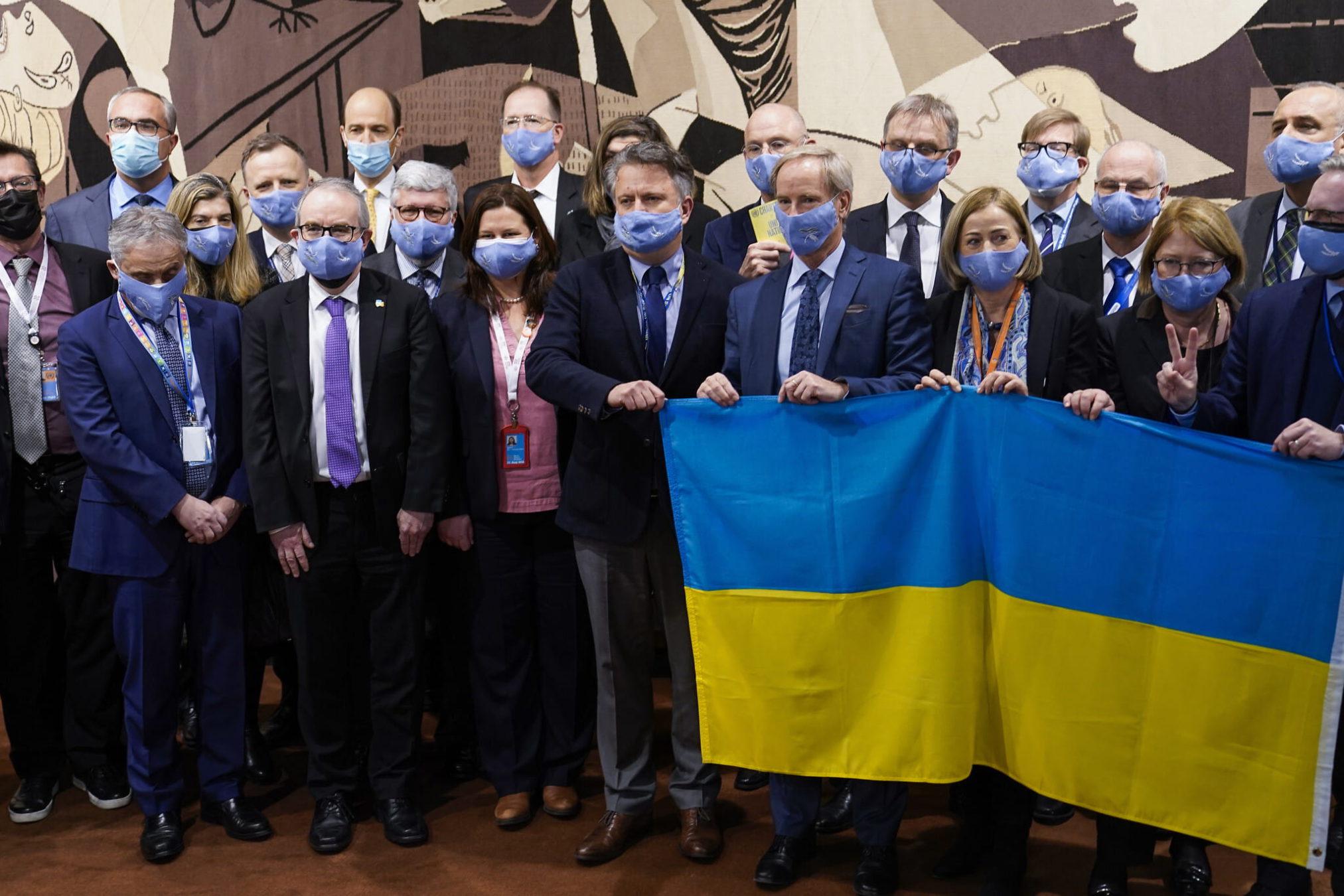 Sergiy Kyslytsya, embajador de Ucrania ante las Naciones Unidas, en el centro, sostiene una bandera mientras está flanqueado por representantes y ministros de la Unión Europea fuera de la sala del Consejo de Seguridad, el viernes 25 de febrero de 2022, en la sede de las Naciones Unidas. (AP Photo/John Minchillo)
