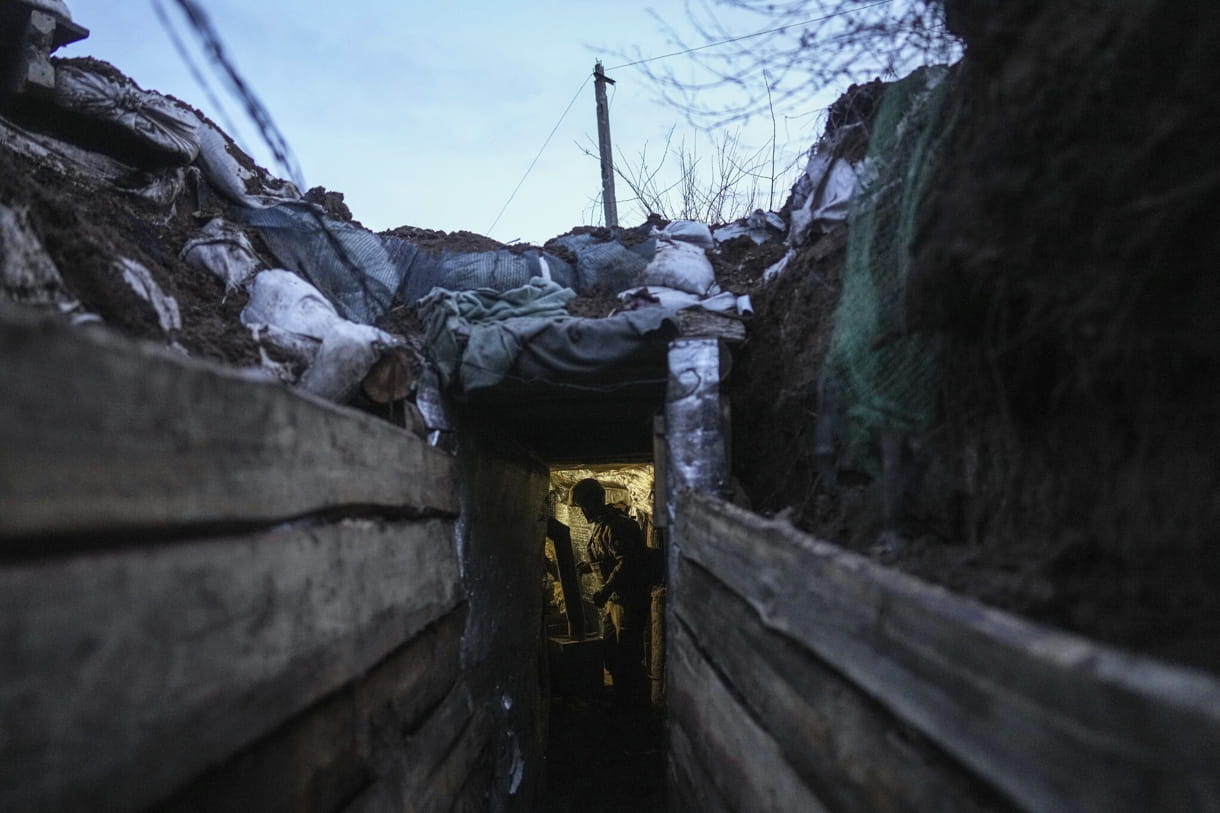 Un militar ucraniano se encuentra en un refugio en una posición en la línea de separación entre el territorio controlado por Ucrania y el territorio controlado por los rebeldes cerca de Zolote, Ucrania, 19 de febrero de 2022. (Evgeniy Maloletka/AP)